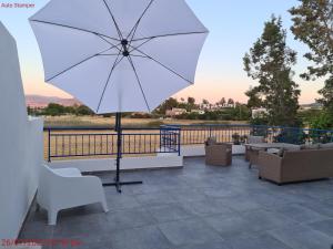 a large white umbrella sitting on a patio at Latchi Area Apartments in Lachi