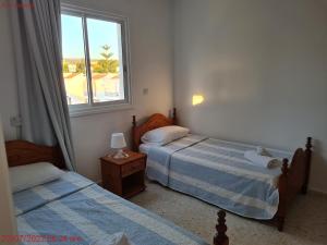 a bedroom with two beds and a window with a view at Latchi Area Apartments in Lachi
