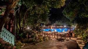 a swimming pool at night with tables and chairs at Fener Motel in Şile