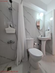 a white bathroom with a toilet and a sink at Latchi Area Apartments in Lachi