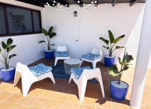 a patio with four chairs and potted plants at Nazaret Villa with heated pool in Nazaret +64 photos