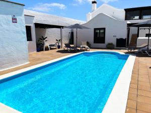 a swimming pool in front of a house at Nazaret Villa with heated pool in Nazaret