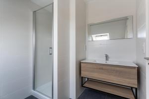 La salle de bains blanche est pourvue d'un lavabo et d'un miroir. dans l'établissement Le Refuge Marin - Gîte familial au bord de mer, à Lamballe 25 autres photos