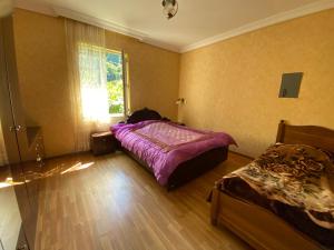 a bedroom with a purple bed and a window at Venera's Guest House in Batumi