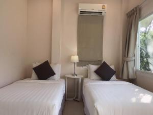 dwa łóżka w pokoju z oknem w obiekcie Arantarakiri Resort Khao Yai w mieście Mu Si