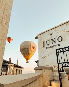 two hot air balloons are flying over a building at Juno Cappadocia Adults Only in Uchisar