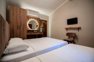 a bedroom with two beds and a desk and a mirror at Fener Motel in Şile