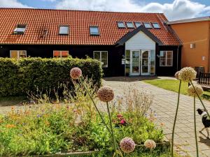 a house with a flower garden in front of it at Nexø Modern Hostel. Private Rooms in Neksø