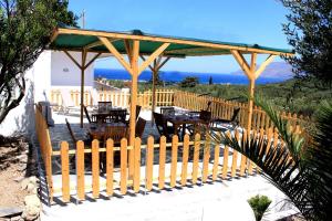 un pavillon en bois avec des tables et une clôture en bois dans l'établissement Village Villa Marika - Mimis Drapanias, à Dhrapaniás