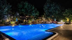 a swimming pool lit up at night at Fener Motel in Şile