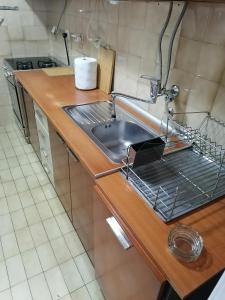 a kitchen sink with a dish drying rack next to it at Apartman Kolubara 14 in Valjevo
