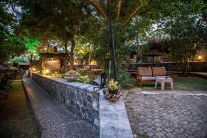 a garden at night with a stone wall and trees at Fener Motel in Şile