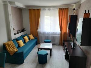 a living room with a blue couch and a table at Apartman Kolubara 14 in Valjevo