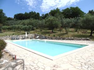 una grande piscina in un cortile con passerella in pietra di Agriturismo Camera Rosa a Todi