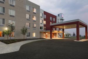 a rendering of a hospital building with a parking lot at Motel 6 Airdrie in Airdrie