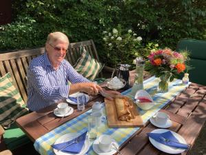 an older man sitting at a table with a table cloth at Thoreys Ferienwohnung in Soltau in Soltau