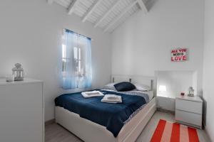 1 dormitorio con cama con sábanas azules y ventana en T Monte en Porto Covo