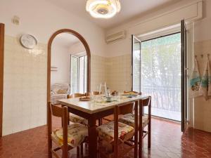 ein Esszimmer mit einem Tisch mit Stühlen und einem Spiegel in der Unterkunft Ca' du Tasci8 by Holiday World in Cogoleto