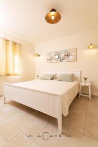 a large white bed in a white bedroom at Villa Carolina in Izola