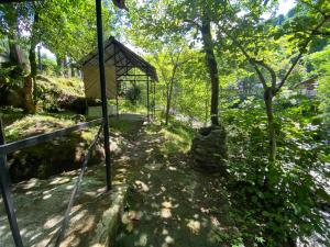 a walkway leading to a gazebo in a forest at Venera's Guest House in Batumi