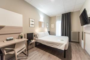 um quarto de hotel com uma cama e uma secretária em Green Class Hotel Gran Torino em Turim