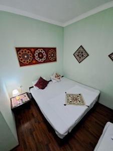Habitación pequeña con cama con sábanas blancas. en OLD CITADEL with Terace, en Bukhara