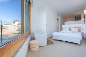 - une chambre blanche avec un lit et une fenêtre dans l'établissement CASA UMI - Magnifique appartement avec accès privé à la mer et grande terrasse, à Marseille