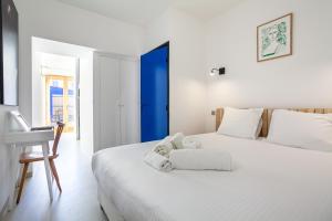 Biała sypialnia z białym łóżkiem i biurkiem w obiekcie CASA UMI - Magnifique appartement avec accès privé à la mer et grande terrasse w Marsylii