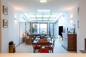 een eetkamer en een woonkamer met een tafel en stoelen bij CASA UMI - Magnifique appartement avec accès privé à la mer et grande terrasse in Marseille