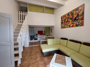 een woonkamer met een bank en een trap bij Gîte L'oliveraie d'Aniane 7 personnes in Aniane
