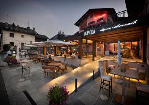 un restaurante con mesas y sillas por la noche en Hotel Astra, en Livigno