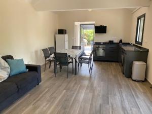 a living room with a couch and a table and a kitchen at Bungalow Coco des sables proche plage et lagon in La Saline les Bains
