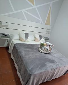 una camera da letto con un grande letto con una parete bianca di Casa Abian ad Arrecife