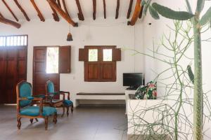 a living room with chairs and a table and a tv at Unique House Elena Barichara Open Space Bright in Barichara