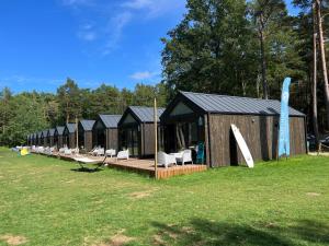a row of lodges in a field with chairs at Ustronie Park - beach resort in Ustronie Morskie