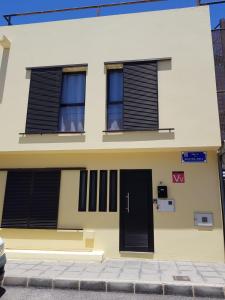 a yellow house with black shutters on it at Casa Abian in Arrecife