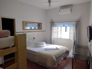 a small bedroom with a bed and a window at Pousada do Mendonça in Juiz de Fora