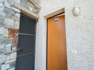 a brown door on a building with a shutter at Terrazze di Costa - Gardegna 3 in Bellano
