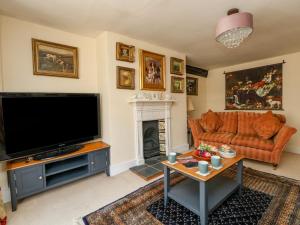 sala de estar con TV y chimenea en The Town House, en Dorchester