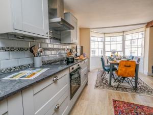 a kitchen with white cabinets and a table in it at The Town House in Dorchester