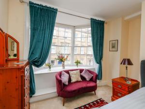 a bedroom with a red chair and a window at The Town House in Dorchester