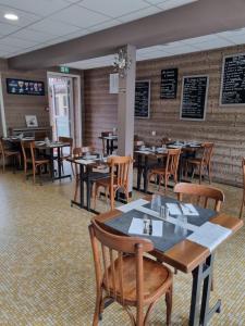 a dining room with tables and chairs in a restaurant at hotel du commerce in Fauville-en-Caux