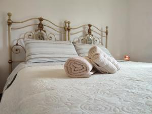 a white bed with two towels on it at Gio Horses B&B in Sannicandro Garganico