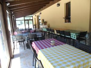 una sala da pranzo con tavoli e sedie e una stanza con finestre di Agriturismo Camera Rosa a Todi