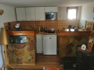 a kitchen with white cabinets and a stone wall at Mala Kelja in Rudnik