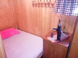 a small room with a bed and a tv in it at Mala Kelja in Rudnik