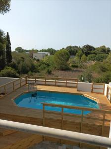 a swimming pool with a wooden deck and a swimming poolvisor at Vele del Pizzo - piscina in Gallipoli
