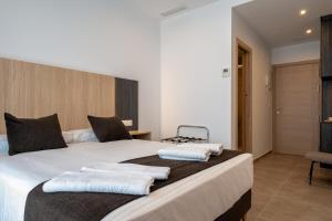 a bedroom with a large white bed with towels on it at Plaza de la Luz Cádiz in Cádiz