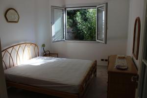 a bedroom with a bed and a window at Villa Giuliana in Pisciotta
