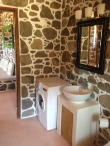 a bathroom with a washing machine and a sink at Loutra Olive Garden Stone House #2 in Mandrákion